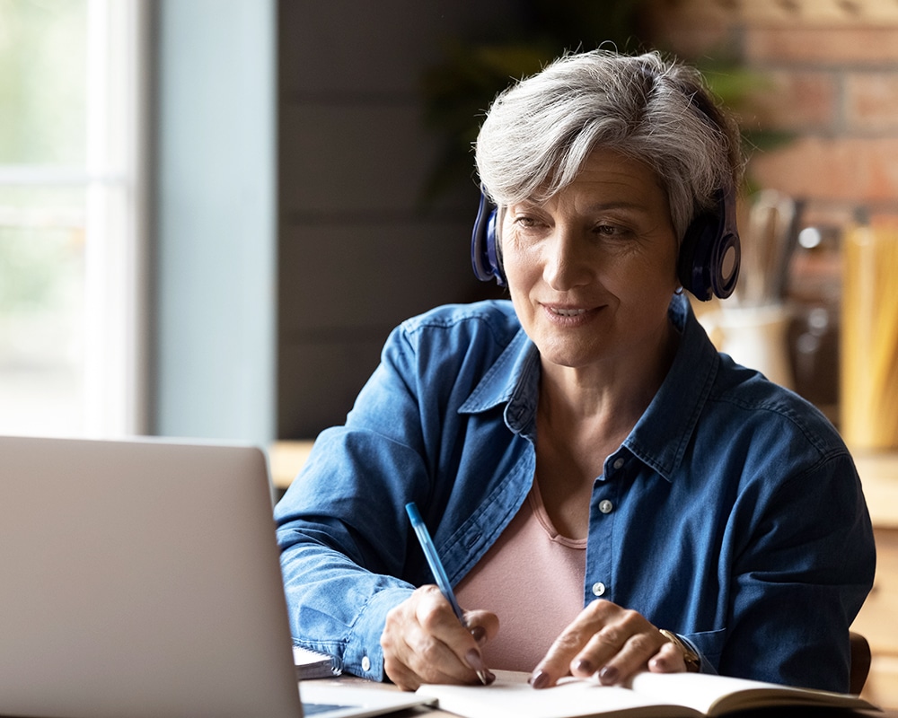 Mujer de avanzada edad recibiendo formación online desde casa