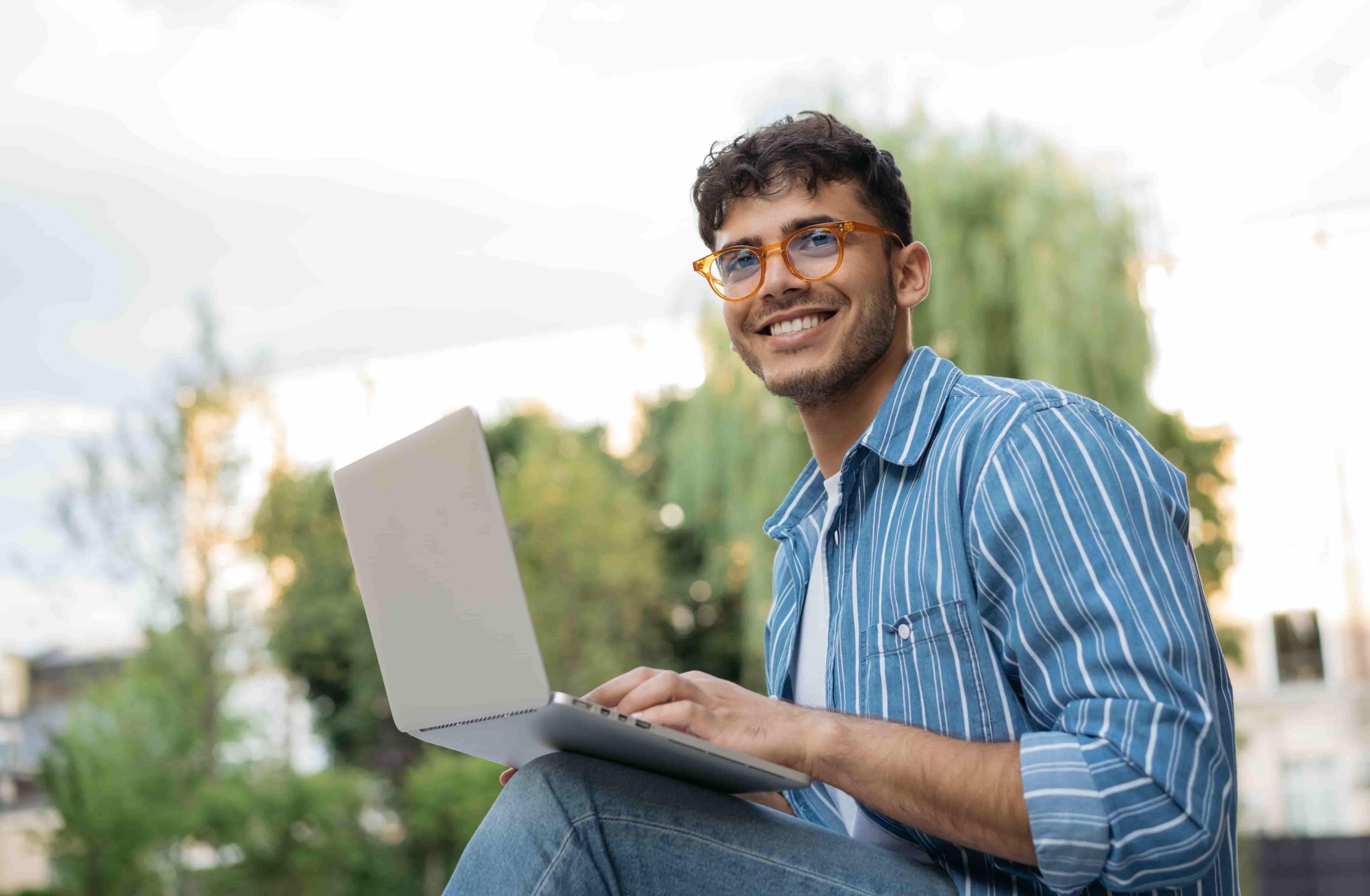 Hombre al aire libre trabajando con un portátil