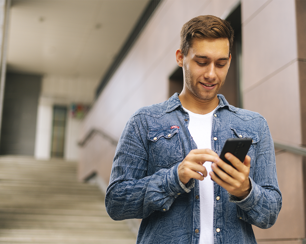 Hombre usando un móvil para conectarse a una red wifi pública